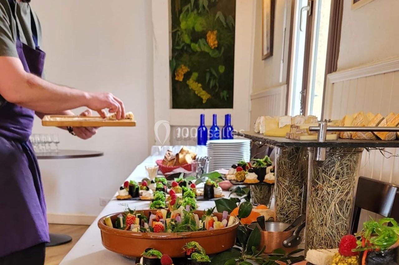 Location salle Bordeaux (Gironde) - Restaurant Le Family #6 Un buffet garni de plats variés et colorés, avec un serveur disposant des assiettes sur une table.
