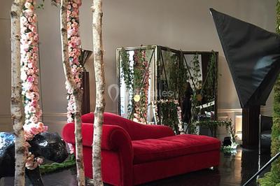 Table ronde en métal noir avec chandelier et chaises, placée sur un balcon avec vue sur une façade d'immeuble haussmannien.