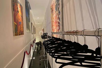 Table ronde en métal noir avec chandelier et chaises, placée sur un balcon avec vue sur une façade d'immeuble haussmannien.