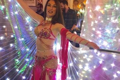 Table ronde en métal noir avec chandelier et chaises, placée sur un balcon avec vue sur une façade d'immeuble haussmannien.