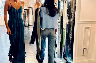 Table ronde en métal noir avec chandelier et chaises, placée sur un balcon avec vue sur une façade d'immeuble haussmannien.