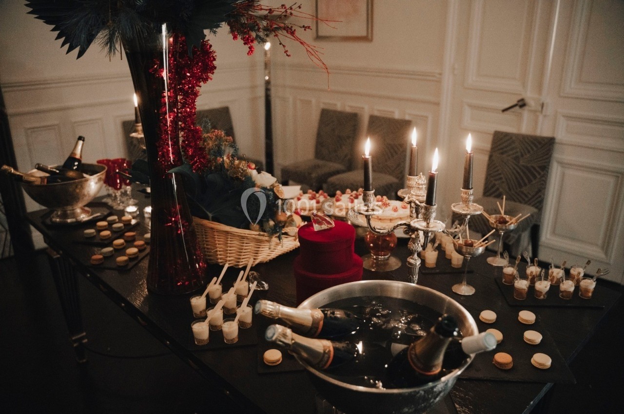 Location salle Paris 8 (Paris) - Le Loft Triangle d'Or Champs-Élysées #41 Table festive décorée avec des bougies, des desserts, des macarons et des bouteilles de champagne dans des seaux à glace.