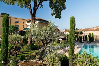 Table de réception élégamment dressée avec menu, verres, et centre de table floral composé de roses rouges et blanches.