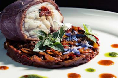 Table de réception élégamment dressée avec menu, verres, et centre de table floral composé de roses rouges et blanches.