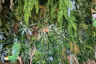 Salle de réception décorée en noir et blanc avec tables dressées, chaises blanches et lanternes suspendues.