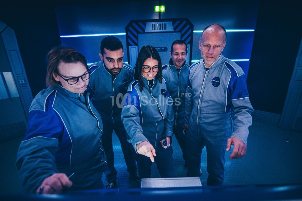 Un groupe de personnes en tenue uniforme observe et interagit avec un écran dans un environnement futuriste.
