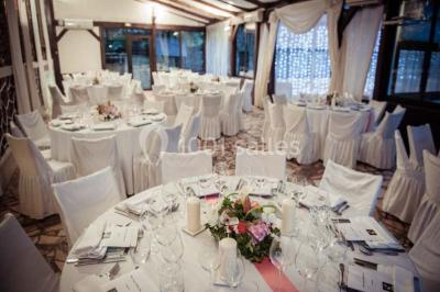 Intérieur élégant avec décorations classiques, horloge, miroir, fleurs et cage décorative dans une lumière tamisée.