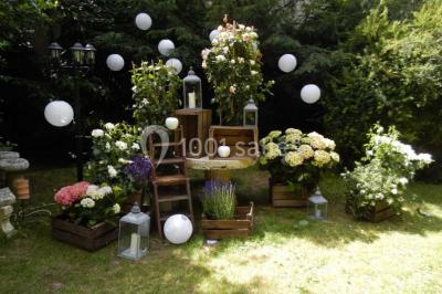 Intérieur élégant avec décorations classiques, horloge, miroir, fleurs et cage décorative dans une lumière tamisée.
