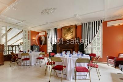 Intérieur élégant avec décorations classiques, horloge, miroir, fleurs et cage décorative dans une lumière tamisée.