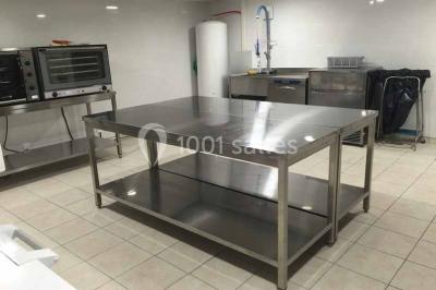 Miniature Location salle Villeneuve-lès-Maguelone (Hérault) - Salle de la Maguelone #15 Table en inox avec étagère inférieure dans une cuisine professionnelle équipée de fours et d'équipements.