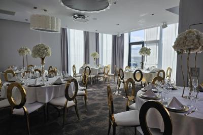 Chambre d'hôtel moderne avec lit double, salle de bain vitrée, lavabo double et lumière naturelle.