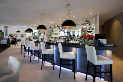 Miniature Location salle Mons (Hainaut) - Congrès Hôtel Mons Van Der Valk #2 Salle de réunion moderne avec table rectangulaire, chaises noires, écran mural, tableau blanc et minibar.