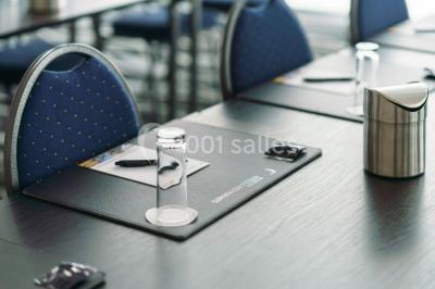 Miniature Location salle Mons (Hainaut) - Congrès Hôtel Mons Van Der Valk #9 Salle de réunion moderne avec table rectangulaire, chaises noires, écran mural, tableau blanc et minibar.