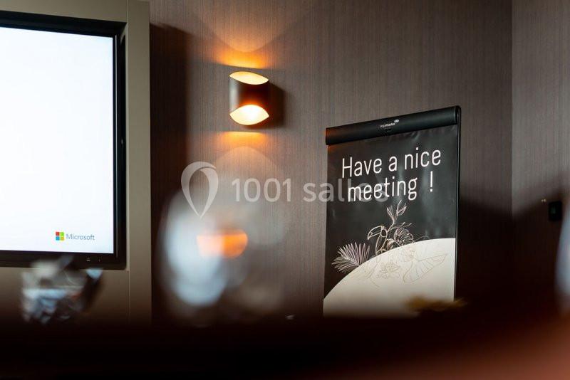 Location salle Nivelles (Brabant wallon) - Hôtel Nivelles Sud #3 Affiche avec le message ’Have a nice meeting !’ posée dans une salle de réunion faiblement éclairée.