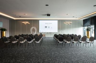 Miniature Location salle Nivelles (Brabant wallon) - Hôtel Nivelles Sud #6 Bornes de recharge électriques Tesla alignées sur un parking, entourées de végétation et de voitures en arrière-plan.