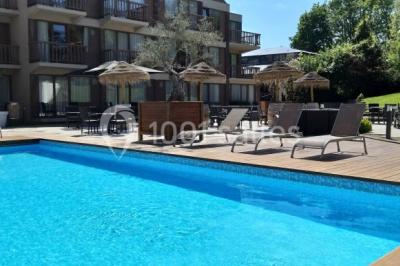 Miniature Location salle Nivelles (Brabant wallon) - Hôtel Nivelles Sud #22 Bornes de recharge électriques Tesla alignées sur un parking, entourées de végétation et de voitures en arrière-plan.