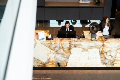 Miniature Location salle Nivelles (Brabant wallon) - Hôtel Nivelles Sud #9 Bornes de recharge électriques Tesla alignées sur un parking, entourées de végétation et de voitures en arrière-plan.