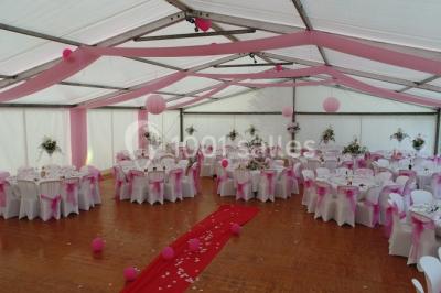 Deux roulottes rouges avec portes vertes, posées sur un terrain herbeux devant des arbres en automne.