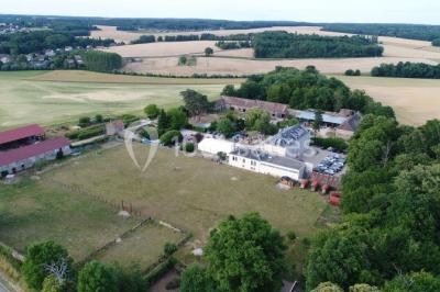 Deux roulottes rouges avec portes vertes, posées sur un terrain herbeux devant des arbres en automne.