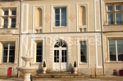 Deux roulottes rouges avec portes vertes, posées sur un terrain herbeux devant des arbres en automne.