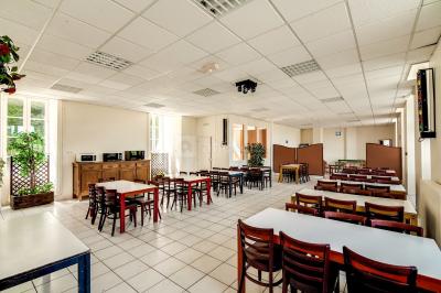 Deux roulottes rouges avec portes vertes, posées sur un terrain herbeux devant des arbres en automne.