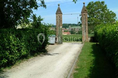 Deux roulottes rouges avec portes vertes, posées sur un terrain herbeux devant des arbres en automne.