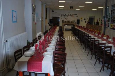 Deux roulottes rouges avec portes vertes, posées sur un terrain herbeux devant des arbres en automne.