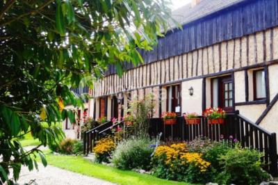 Tente rouge et blanche abritant des tables dressées avec nappes et décorations pour un repas en extérieur.