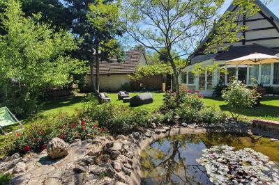 Tente rouge et blanche abritant des tables dressées avec nappes et décorations pour un repas en extérieur.
