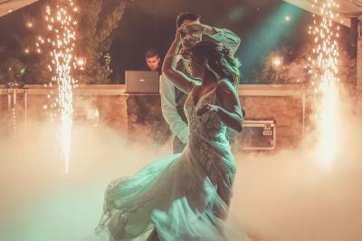 Tente rouge et blanche abritant des tables dressées avec nappes et décorations pour un repas en extérieur.