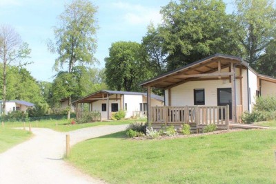 Salle de bain moderne avec lavabo, miroir, toilettes suspendues et douche en arrière-plan.