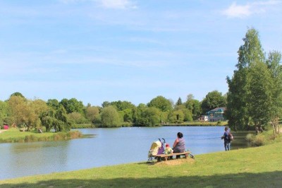 Salle de bain moderne avec lavabo, miroir, toilettes suspendues et douche en arrière-plan.