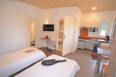 Salle de bain moderne avec lavabo, miroir, toilettes suspendues et douche en arrière-plan.