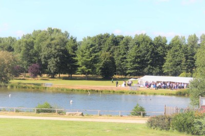 Salle de bain moderne avec lavabo, miroir, toilettes suspendues et douche en arrière-plan.