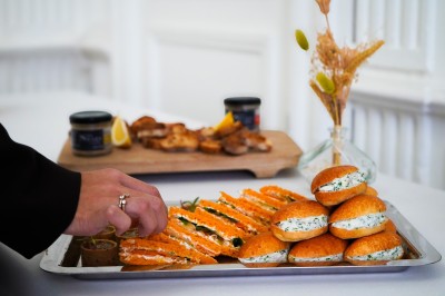 Plantes d'intérieur variées dans des pots en verre et en métal doré, disposées sur une cheminée en marbre noir.