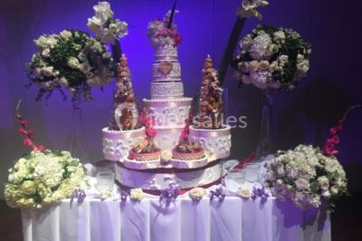 Miniature Location salle Saint-Maximin (Oise) - L'Art d'Oise #24 Salle décorée pour un événement, avec des tables rondes dressées, chaises rouges et un fond floral rose.