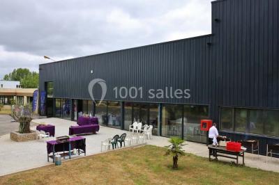 Miniature Location salle Saint-Maximin (Oise) - L'Art d'Oise #18 Salle décorée pour un événement, avec des tables rondes dressées, chaises rouges et un fond floral rose.