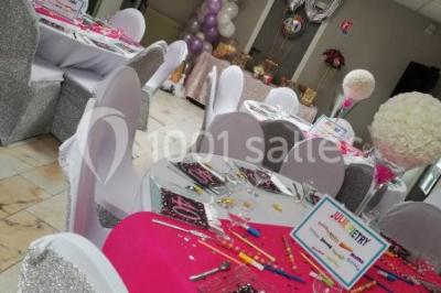 Miniature Location salle Saint-Maximin (Oise) - L'Art d'Oise #32 Salle décorée pour un événement, avec des tables rondes dressées, chaises rouges et un fond floral rose.