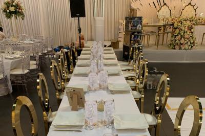 Miniature Location salle Saint-Maximin (Oise) - L'Art d'Oise #8 Salle décorée pour un événement, avec des tables rondes dressées, chaises rouges et un fond floral rose.