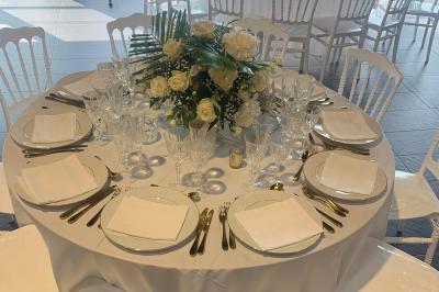 Miniature Location salle Saint-Maximin (Oise) - L'Art d'Oise #39 Salle décorée pour un événement, avec des tables rondes dressées, chaises rouges et un fond floral rose.