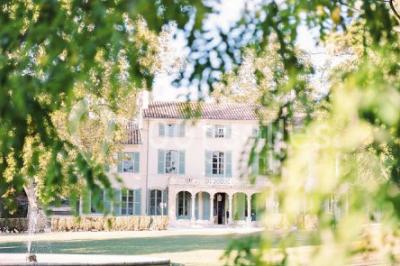 Chaises transparentes disposées en rangées sur une allée blanche, entourées d'arbres dans un cadre extérieur.