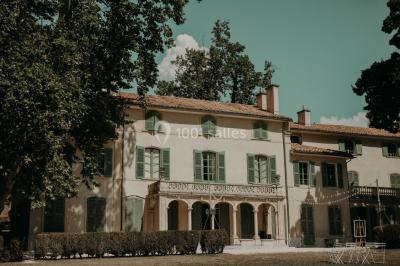 Chaises transparentes disposées en rangées sur une allée blanche, entourées d'arbres dans un cadre extérieur.