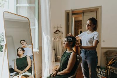 Chaises transparentes disposées en rangées sur une allée blanche, entourées d'arbres dans un cadre extérieur.