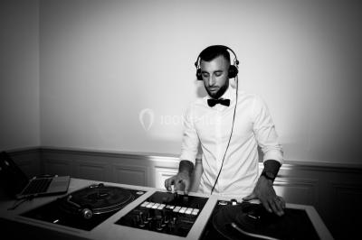 Chaises transparentes disposées en rangées sur une allée blanche, entourées d'arbres dans un cadre extérieur.