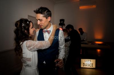 Chaises transparentes disposées en rangées sur une allée blanche, entourées d'arbres dans un cadre extérieur.