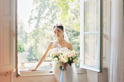 Chaises transparentes disposées en rangées sur une allée blanche, entourées d'arbres dans un cadre extérieur.