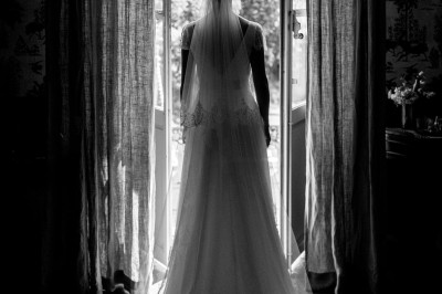 Chaises transparentes disposées en rangées sur une allée blanche, entourées d'arbres dans un cadre extérieur.