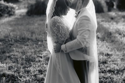 Chaises transparentes disposées en rangées sur une allée blanche, entourées d'arbres dans un cadre extérieur.
