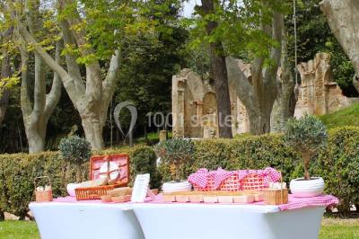 Chaises transparentes disposées en rangées sur une allée blanche, entourées d'arbres dans un cadre extérieur.