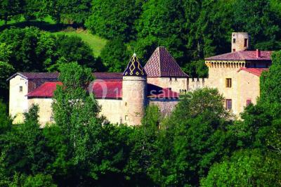 Scooter rose décoré de fleurs roses et blanches, stationné près d'un mur en pierre et d'une porte en bois.